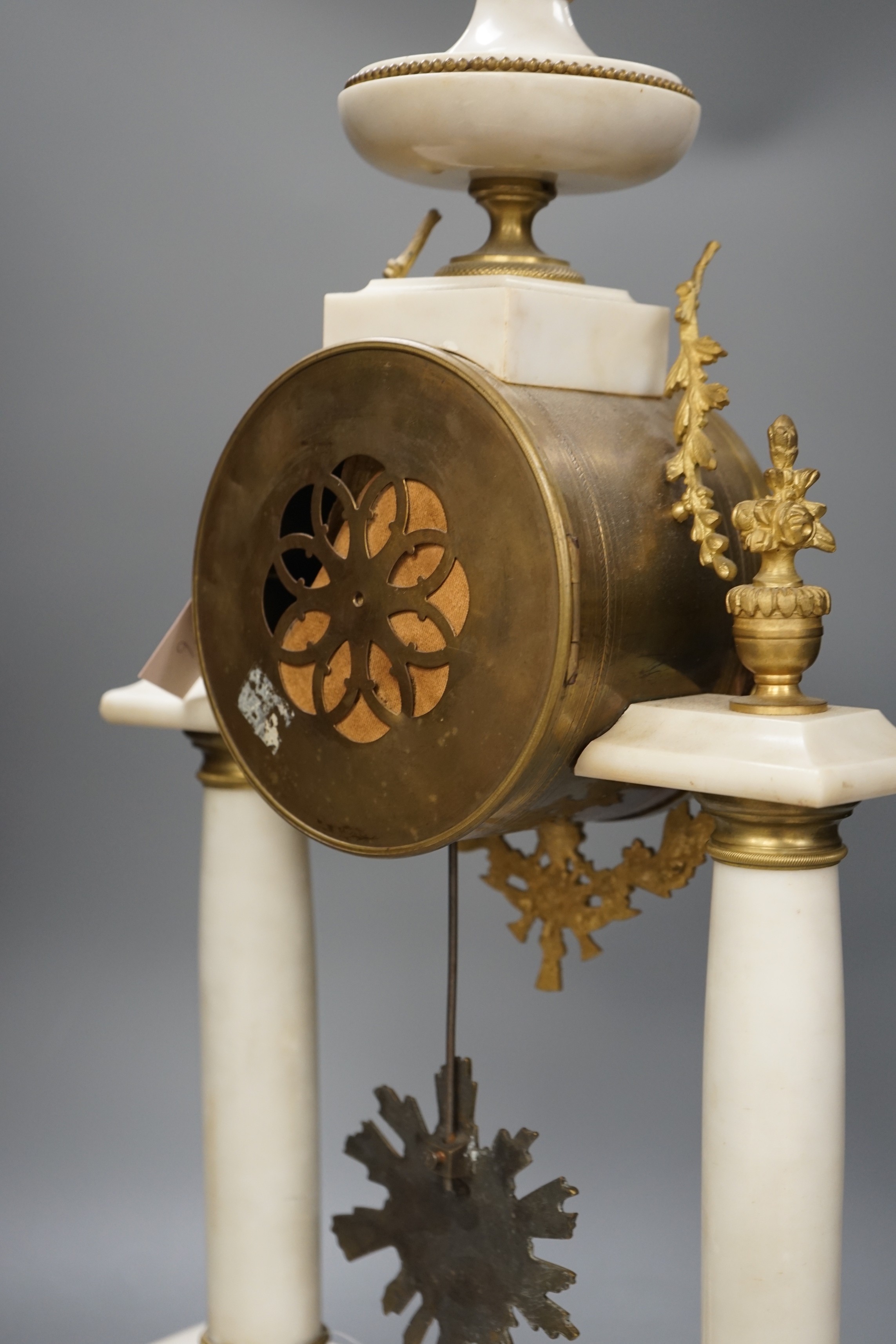 A large French white marble portico clock with ormolu decoration and sunburst pendulum, 59.5cm tall